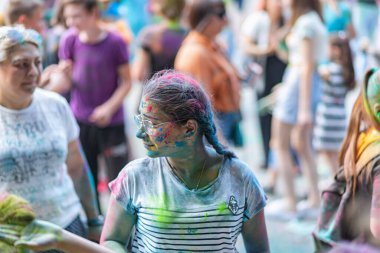 Açık hava boya festivaline boyalı yüzler ve kıyafetlerle katılan mutlu katılımcılar. 20 Haziran 2021 Essentuki, Rusya.