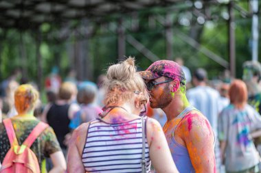 Açık hava boya festivaline boyalı yüzler ve kıyafetlerle katılan mutlu katılımcılar. 20 Haziran 2021 Essentuki, Rusya.