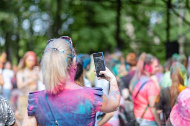 Açık hava boya festivaline boyalı yüzler ve kıyafetlerle katılan mutlu katılımcılar. 20 Haziran 2021 Essentuki, Rusya.