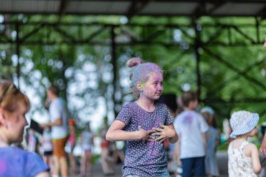 Açık hava boya festivaline boyalı yüzler ve kıyafetlerle katılan mutlu katılımcılar. 20 Haziran 2021 Essentuki, Rusya.