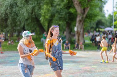 Açık hava boya festivaline boyalı yüzler ve kıyafetlerle katılan mutlu katılımcılar. 20 Haziran 2021 Essentuki, Rusya.