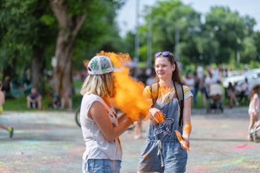 Açık hava boya festivaline boyalı yüzler ve kıyafetlerle katılan mutlu katılımcılar. 20 Haziran 2021 Essentuki, Rusya.