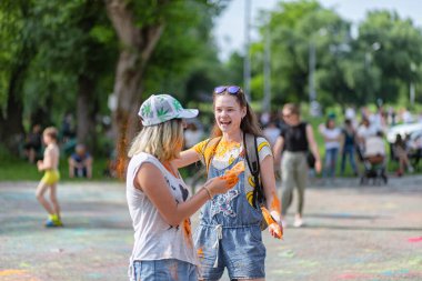 Açık hava boya festivaline boyalı yüzler ve kıyafetlerle katılan mutlu katılımcılar. 20 Haziran 2021 Essentuki, Rusya.