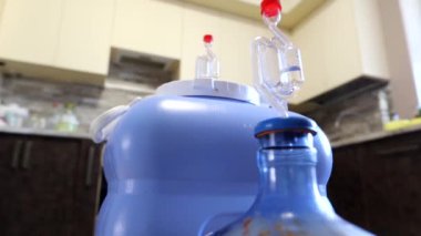 Ev yapımı şarabın mutfakta plastik kaplarda aktif fermantasyonu.