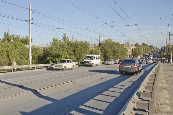 Tráfico a lo largo de la carretera asfaltada llena de varios agujeros y salsas — Foto de Stock