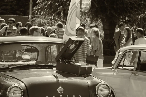 Viejo gramófono, de pie sobre el capó de un coche de época — Foto de Stock