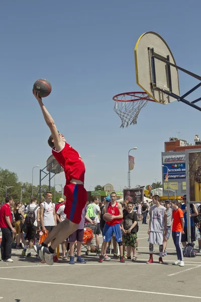 A young basketball player performs a throw to the slam dunk cont — Stock Photo, Image