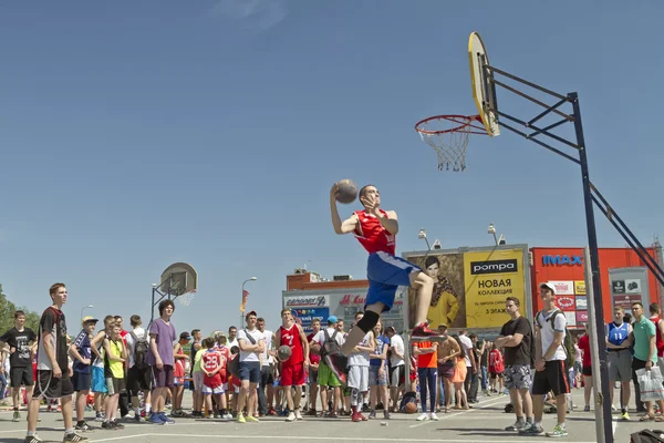 A young basketball player performs a throw to the slam dunk cont — Stock Photo, Image
