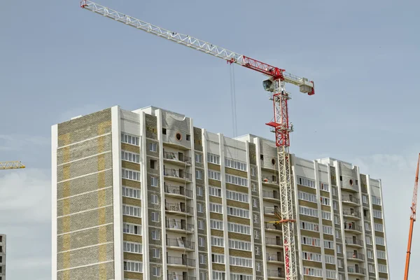 Baksteen bouw van appartement huizen met moderne kranen — Stockfoto