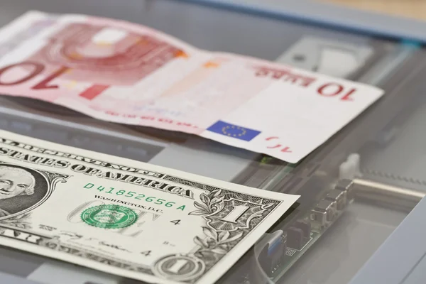 Denominations of one dollar and ten euros lie on scaner — Stock Photo, Image