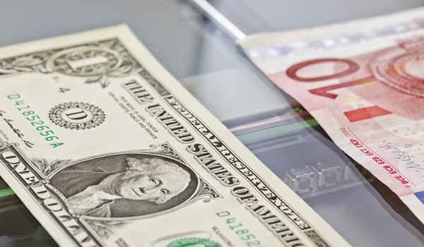 Denominations of one dollar and ten euros lie on scaner — Stock Photo, Image