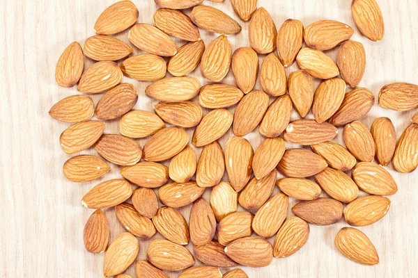 Las almendras yacen sobre una mesa de madera —  Fotos de Stock