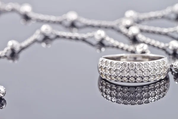 Stříbrný prsten s drahými kameny a jemný stříbrný řetízek — Stock fotografie