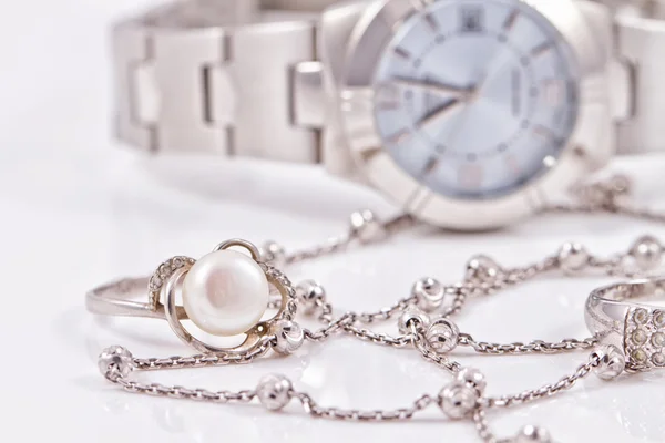 Silver ring and chain on the background of watches — Stock Photo, Image