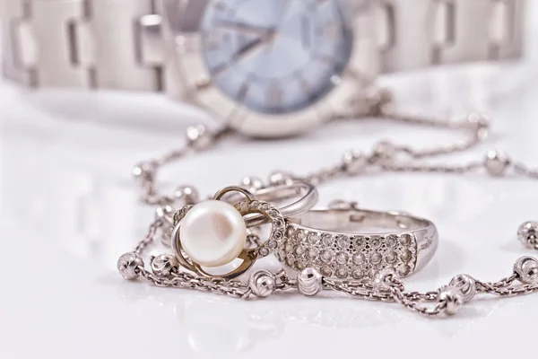 Anel de prata e corrente no fundo dos relógios — Fotografia de Stock