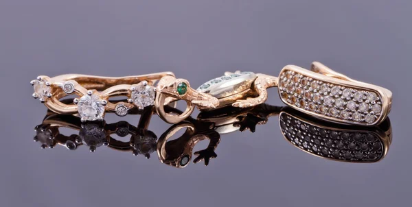 Pendientes de oro de diferentes estilos, colgante en forma de lagarto y elegante cadena de plata —  Fotos de Stock