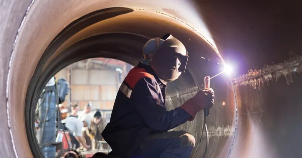 Welder weld root weld from inside of big pipe — Stock Photo, Image