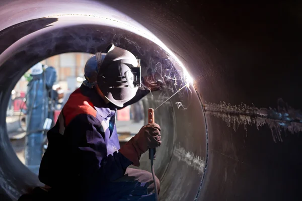 Welder weld root weld from inside of big pipe — Stock Photo, Image