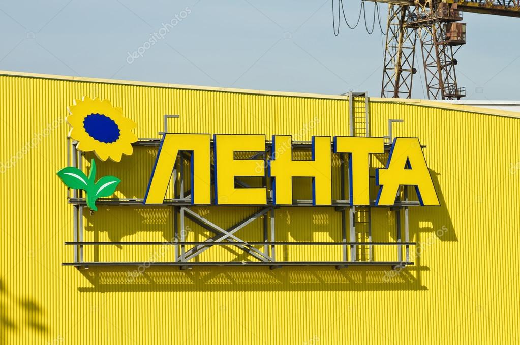 VOLGOGRAD, RUSSIA - SEPTEMBER 30: A sign with the name of the network of hypermarkets tape with a logo in the form of a sunflower hangs on the yellow facade of the new store