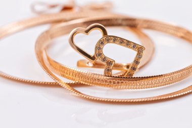 Kalp şeklinde altın küpeler ve altın bir zincir.