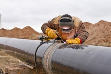 Welding works on gas pipeline clipart