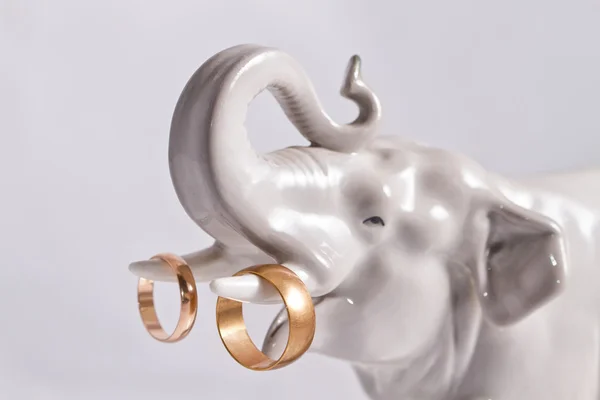 Zlaté snubní prsteny na porcelánu slon figurka — Stock fotografie