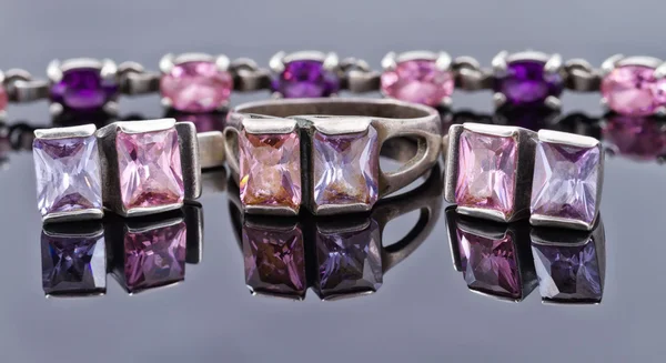 Carved silver ring with earrings with purple gemstones — Stock Photo, Image