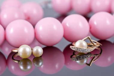 Büyük pembe boncuk ve bir dizi inci ile altın takı