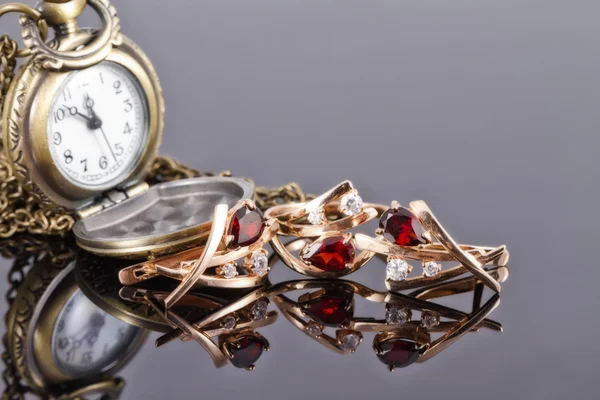 Conjunto de joyas de oro con rubíes y viejo reloj de bolsillo de cobre —  Fotos de Stock