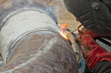 Kaynakçı Kaynak işleri boru hatları paslanmaz çelik üzerinde gerçekleştirir.