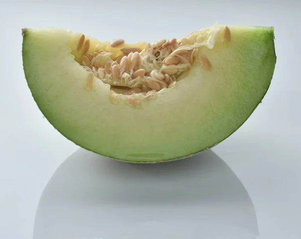Melon cut in half on a white background.