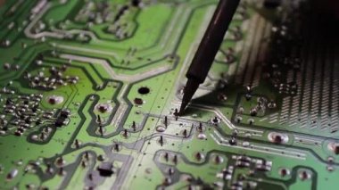 Mühendis ya da teknisyen lehim demiriyle elektronik devre kartını tamir ediyor..