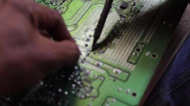 Mühendis ya da teknisyen lehim demiriyle elektronik devre kartını tamir ediyor..