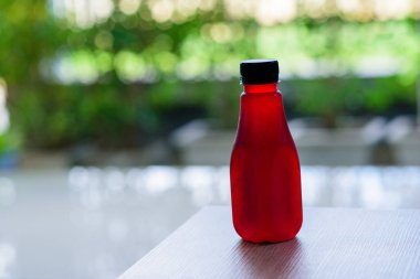 Plastik şişedeki Roselle suyu yeşil arka planda.