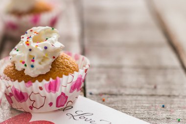 Sevgililer Cupcake ve ahşap arka plan üzerinde bir aşk notu
