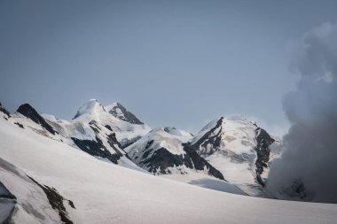 Karla kaplı dağ. Açık bir alp gününde İtalya ve İsviçre sınırında Breithorn, İsviçre Alpleri 'nin dramatik zirveleri, buzulları ve panoramik manzaralarını gözler önüne seriyor.