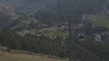 Zermatt 'tan Matterhorn' a yolcu taşıyan teleferik. Arka planda çarpıcı alp zirveleri var.