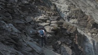 Trekkerlar ve dağcılar arka planda ikonik Matterhorn kulesiyle Hrnlihtte, Matterhorn ana kampına doğru yol alıyorlar..