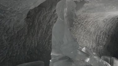 Zermatt, İsviçre - 11 Ağustos 2025: Zermatt 'taki Buzul Bahçesi tünelinde su çeken bir adamın buzdan heykeli.