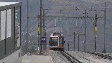 Riffelalp yakınlarındaki Zermatt dağına yaklaşan Gornergrat Demiryolu Treni 'nin arka planında alp zirveleri vardır..