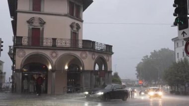 Locarno, İsviçre - 11 Ağustos 2025 Locarno 'da şehir trafiği, otobüs, tren ve gri gökyüzü altındaki binalarla yağmurlu bir gün.