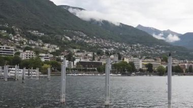 Locarno, İsviçre - 11 Ağustos 2025 Locarno 'da sakin su ve bulutlu gökyüzü ile Maggiore Gölü' nün bulutlu sabah manzarası.