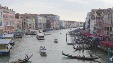 Venedik, İtalya - 12 Eylül 2025: Rialto Köprüsü 'nden Venices Grand Canal' ın turistler, gondol tekneleri ve tarihi liman binalarıyla dolu yoğun manzarası.