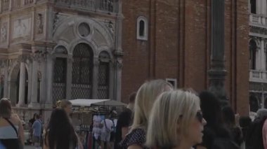 Venedik, İtalya - 12 Eylül 2025: Venices ana meydanını keşfeden turistler, gondollar, tarihi binalar ve canlı şehir hayatı ile San Marco Meydanı.