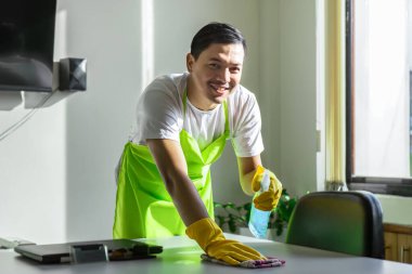 Profesyonel erkek temizleyici elektrik süpürgesi, silecek ve çevre dostu temizlik malzemelerini kullanarak ofis çalışma alanını koruyor, hijyenik ve sürdürülebilir bir iş ortamı sağlıyor.