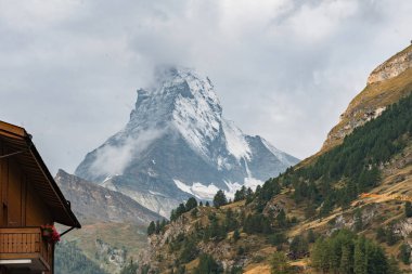 Bulutlu Karla kaplı Matterhorn Dağı ve Geleneksel Alp Chalet, İsviçre