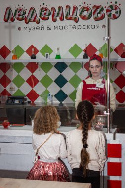 Küçük kızlar karamelli şekerin ustalık sınıfında nasıl yapıldığını öğrenirler.