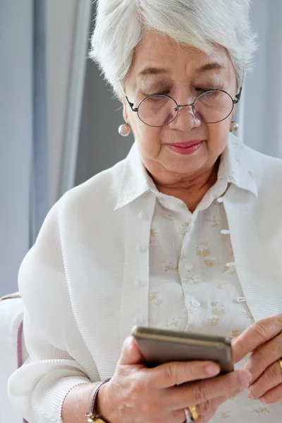 Starší žena pomocí svého mobilního telefonu. — Stock fotografie