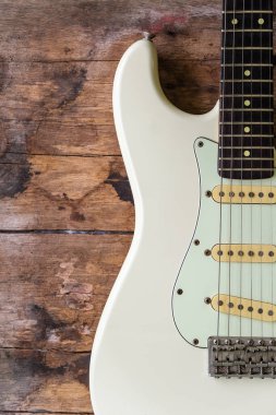 Ahşap arka planda Beyaz Elektrikli Gitarın Detayları.