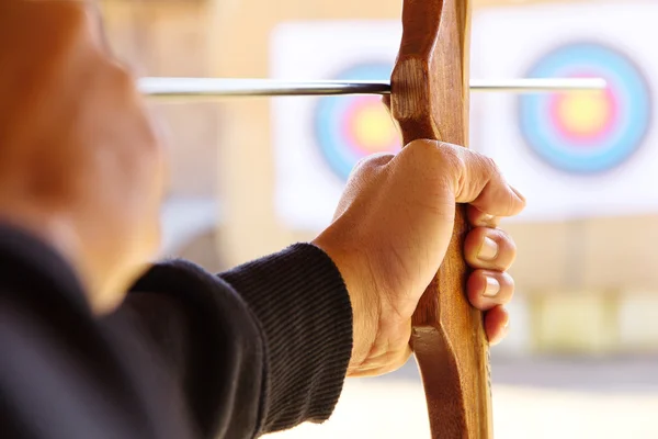 Archer holds his bow aiming at a target — Stock Photo, Image